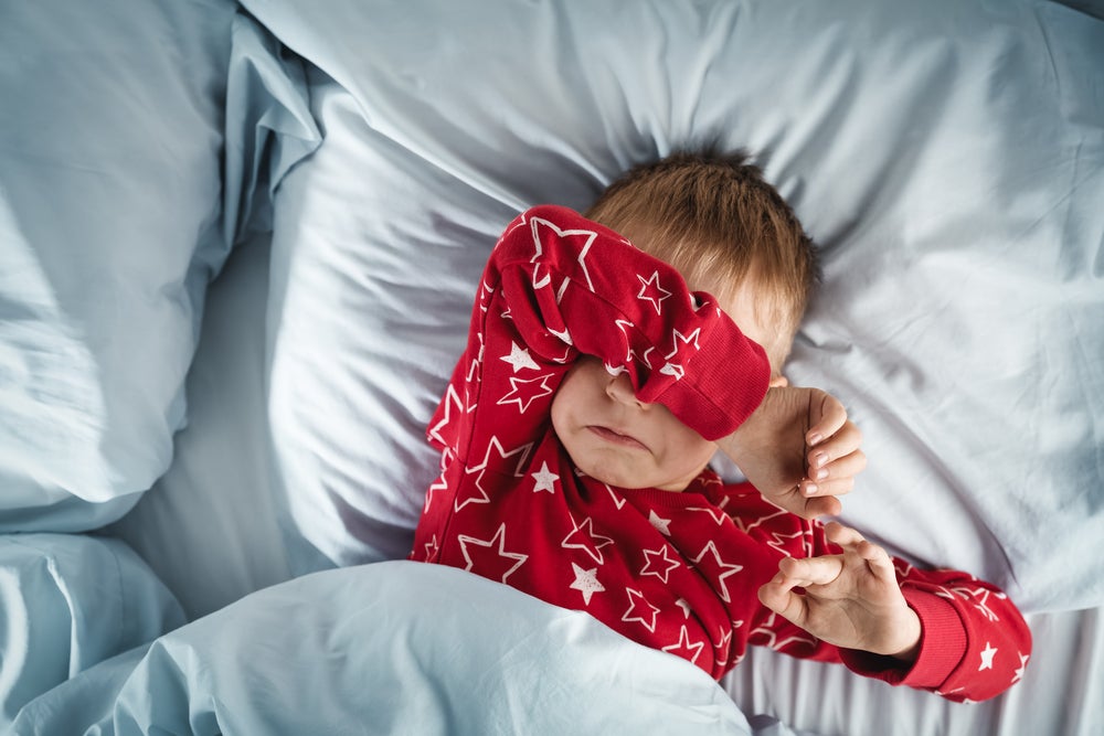 Uma criança com dificuldade para dormir, um dos sintomas dos distúrbios do sono infantil.