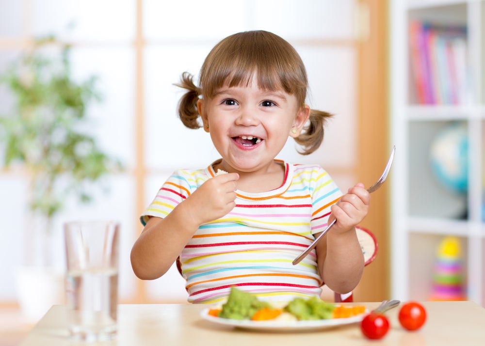 criança feliz se alimentando saudável
