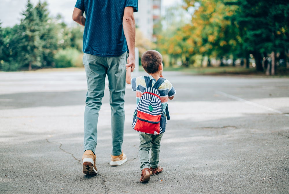 Pai e filho andando de mãos dadas na rua