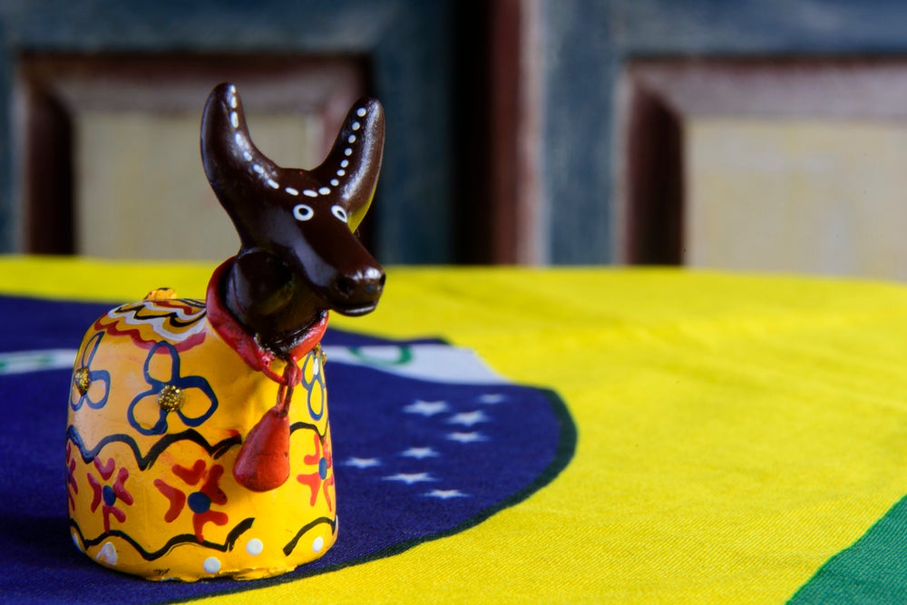 Imagem de um objeto do bumba meu boi, em cima da bandeira do Brasil representando o folclore 