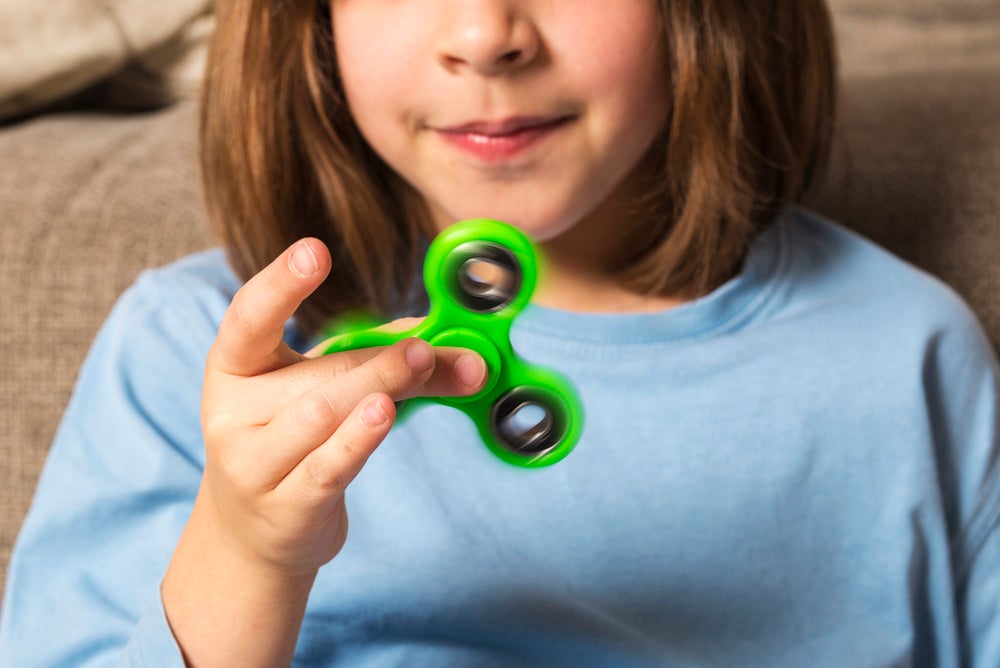 criança brincando com um fidjet spinner