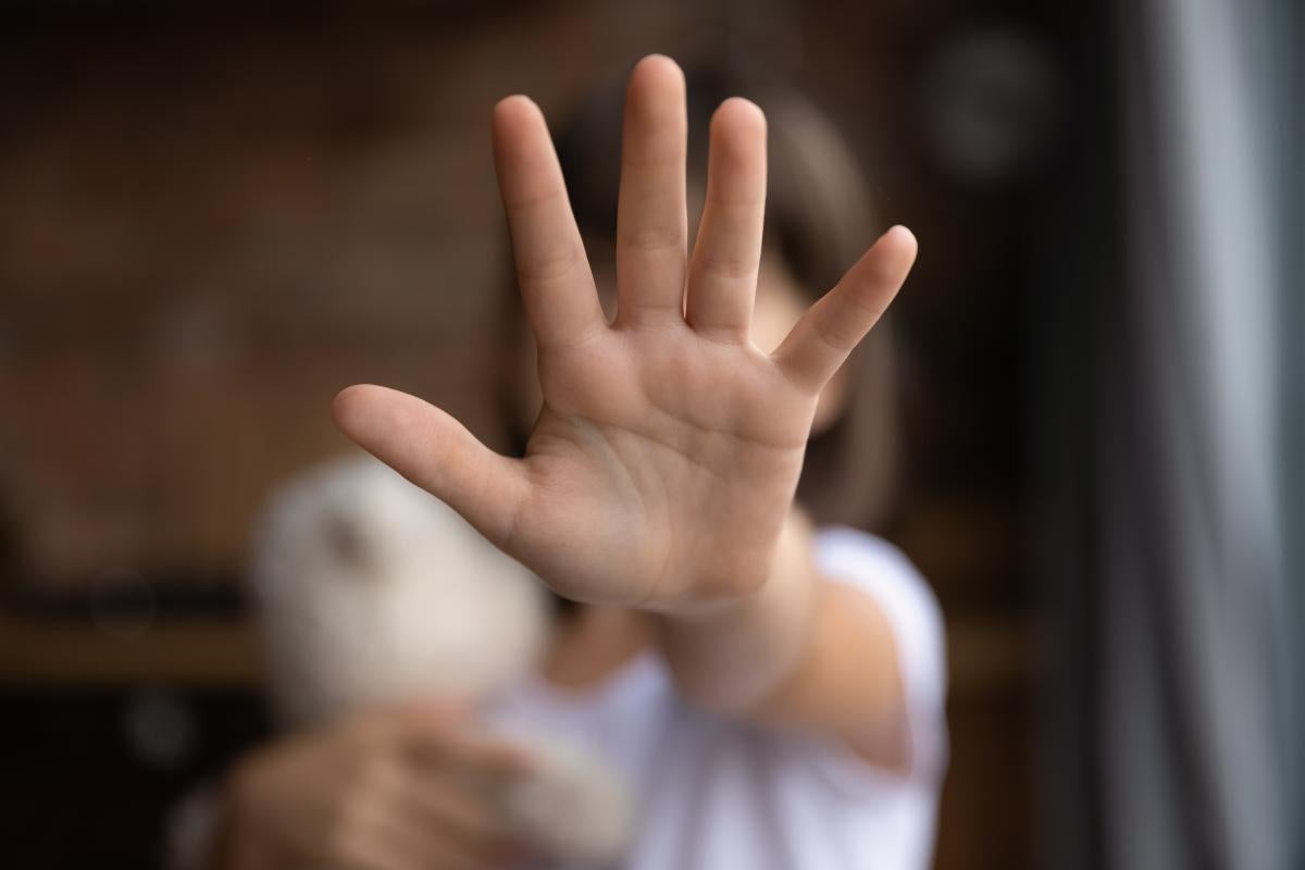 Descrição da Imagem: Uma criança estende a mão aberta para a câmera, um dos símbolos da luta contra o bullying nas escolas. 
