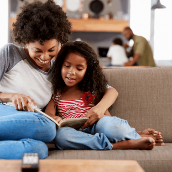 Mãe e filha lêem juntas, um tipo de brincadeira para criança.