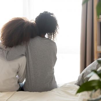 O peso das cobranças excessivas nas crianças Mãe e filha se abraçam sentadas na cama.