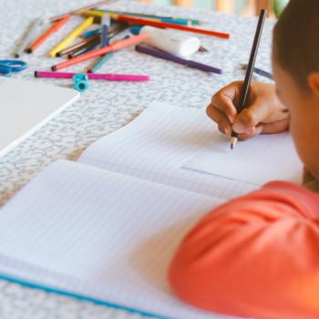 menino escrevendo em um caderno