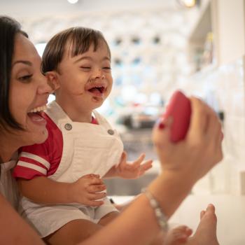 a imagem mostra uma mulher e um menino sorrindo, tirando uma selfie após ele ter comido chocolate.