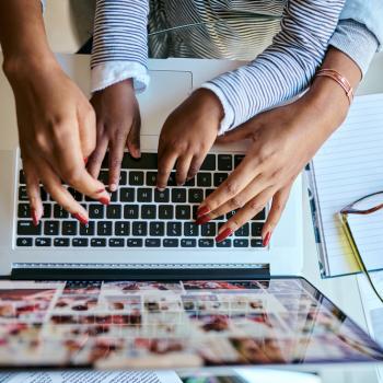 A foto mostra as mãos de uma mulher adulta e de uma criança digitando em um notebook para encontrar as respostas das perguntas difíceis feitas pela criança