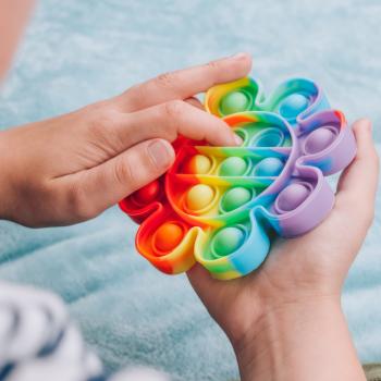 Criança brincando com um brinquedo sensorial chamado fidget toys