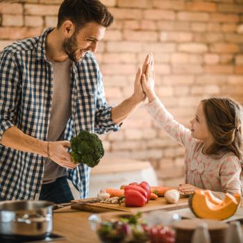 Pai e uma criança vegetariana cozinham apenas com legumes e vegetais. 