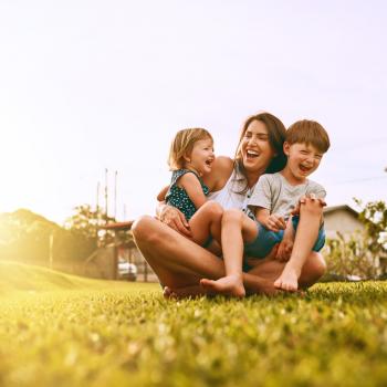 "mãe reunida com dois filhos em um ambiente aberto"