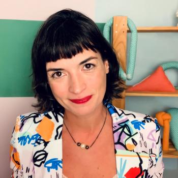 Os livros podem ajudar na educação antirracista? Uma mulher branca sentada enquanto olha para uma câmera