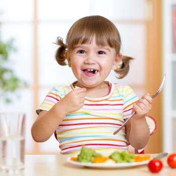 criança feliz se alimentando saudável
