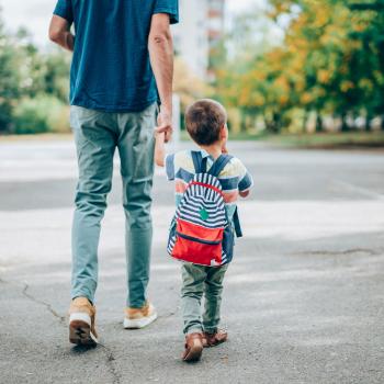 Pai e filho andando de mãos dadas na rua