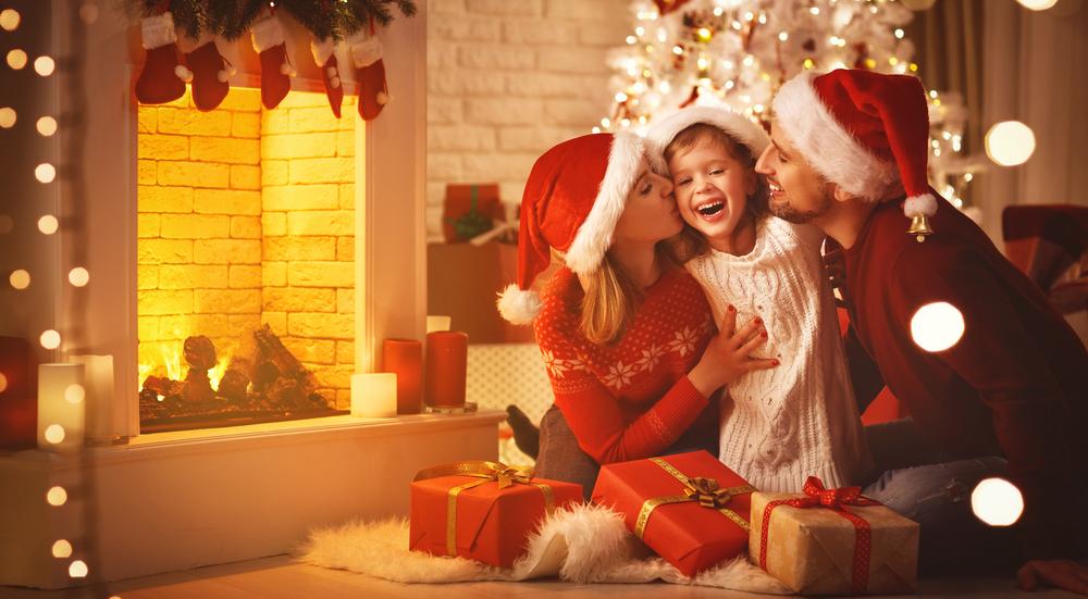 Família vestida de papai noel existe abraçando criança